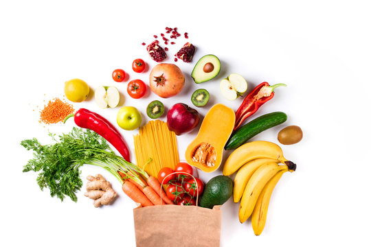 Healthy food background. Healthy food in paper bag pasta, vegetables and fruits on white. Shopping, vegetarian, balanced food concept. Top view