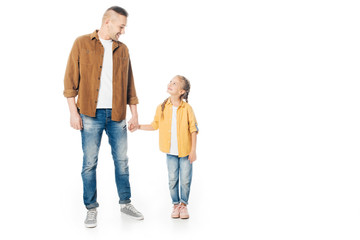 Fototapeta premium father and little daughter looking at each other and holding hands isolated on white