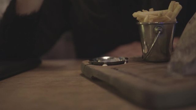 Close up of female hand Dipping fries in sauce.