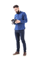Serious business man holding and checking virtual reality glasses headset. Full body isolated on white background. 