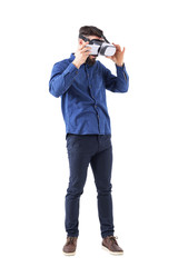 Young business man putting smart phone in virtual reality headset. Full body isolated on white background. 