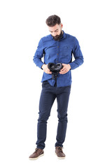 Fototapeta premium Front view of young bearded business man holding and looking down examining vr headset. Full body isolated on white background. 