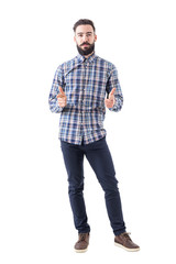 Bearded business man in plaid shirt pointing with amused expression looking at camera. Full body isolated on white background. 
