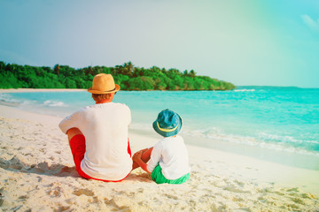 father and little son looking at sea on beach