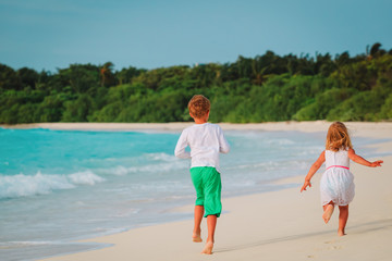 little boy and girl run on beach