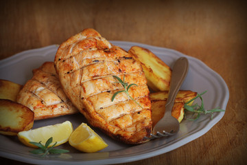 Grilled chicken breast with fried potato and lemon