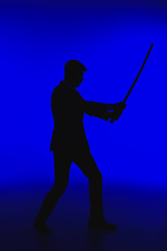toned picture of silhouette of agent in suit with Katana