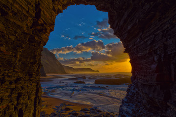 View to the sea sunset from inside a cave at Barriga Beach, Portugal