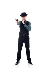spy agent in hat and eyeglasses with gun in hand showing silence sign isolated on white