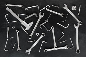 Tools scattered in a chaotic manner on black background. Top view