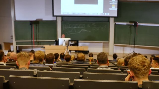 Professor or teacher delivers a lecture college to a large audience of students 