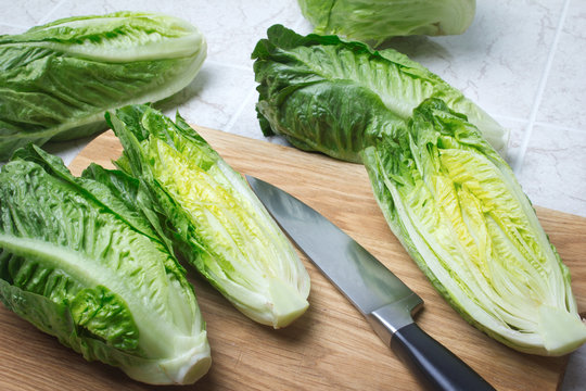 Romaine lettuce on kitchen board with knife