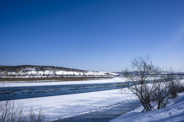 river during the sunset quietly flowing flows through the forest in early spring when there is still ice and snow. Spring landscape