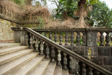 beautiful original staircase with a railing of stone in a green park in summer