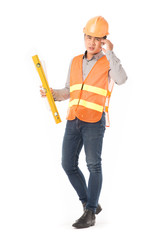 Studio portrait of construction worker in orange waistcoat and hardhat holding levelling tool and building plan