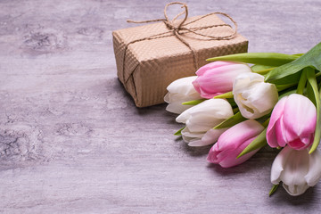 Spring tulip flowers pink, white, red, gift, present box  on  vintage grey table . Greeting for Womens or Mothers Day.