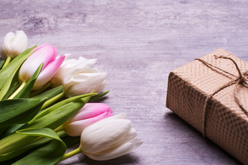 Spring tulip flowers pink, white, red, gift, present box  on  vintage grey table . Greeting for Womens or Mothers Day.