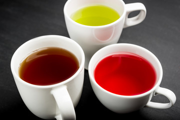 Variety of tea in a white Cup on a dark background. Red , green, black tea.Top view