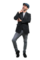 Handsome modern man with beret and glasses standing and thinking an idea