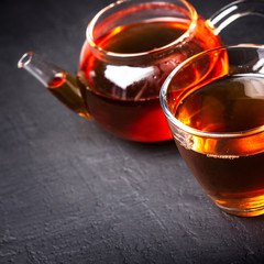 Tea,brewed in a transparent teapot.Dark background.The view from the top.