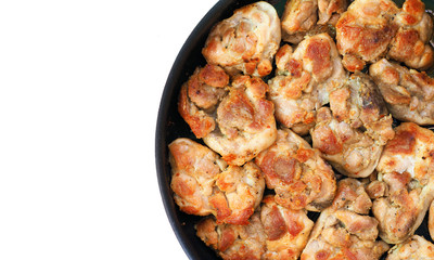 Fragment of the frying pan with pieces of roasted meat isolated on white background. Top view. Space for text