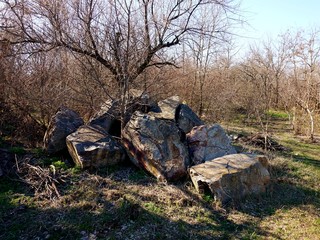 Fototapeta na wymiar Folded granite stones in the forestor in the park. A bright sunny day in the spring.