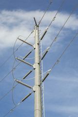Many high voltage power lines on a blue sky background