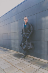 brutal man in a jacket and glasses on the street