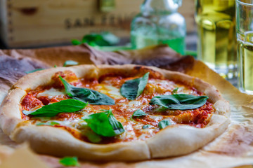 Pizza margarita on parchment, glasses with juice side view