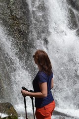 Young woman admires the waterfall