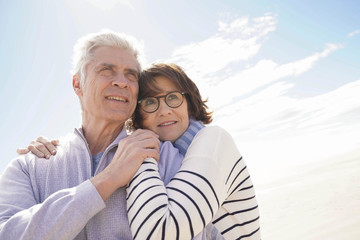 Portrait of senior couple embracing by the beach