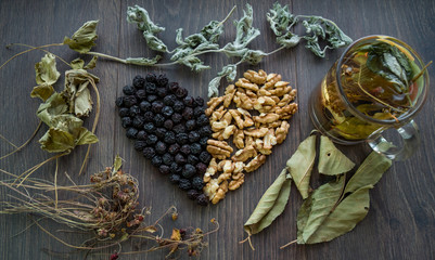 heart of dried cherries, nuts and dried leaves of tea, cup of herbal tea