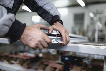 Manual worker assembling PVC doors and windows. Manufacturing jobs. Selective focus. Factory for aluminum and PVC windows and doors production.