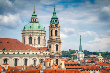 Beautiful summer view on Church of St. Nicholas red tile roofs in Prague from Vrtba garden