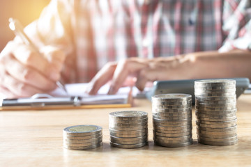 Men are Saint documents about save money  with  some coins calculator  on desk.