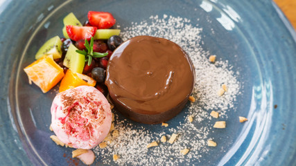 Chocolate cake lava and strawberry ice cream on a blue plate.