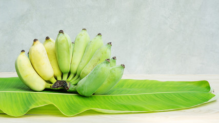 Pisang Awak banana on a banana leaf and wooden table. © supaleka