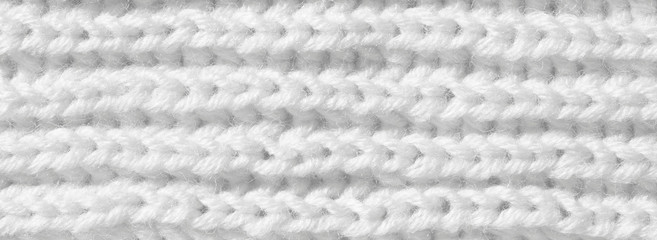 Knitting from woolen threads handmade. The texture is white, the background of the canvas is connected from the thread.