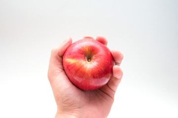 Holding an apple in the hand from below isolated on white background