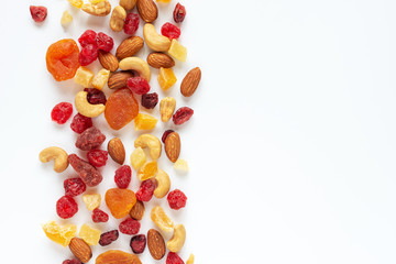 healthy snack: mixed nuts and dried fruits on white background, almond, pineapple, cranberry,...
