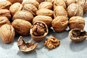 Walnut kernels and whole walnuts on rustic old table