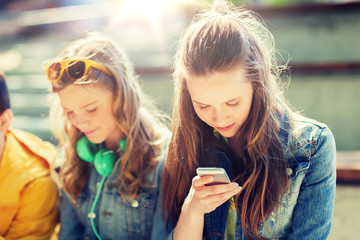 technology, internet addiction and people concept - happy teenage friends with smartphones outdoors