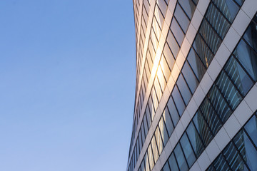 Glass facade of a business center with reflection of light rays