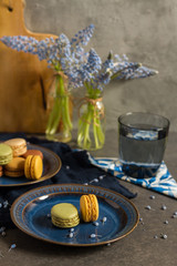 Macaroons and coffee. Dark blue plate, gray background. 