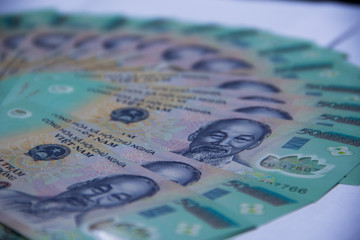 Naklejka premium Vietnamese money dong on white table. Just printed asian money. Asian money fan out. Concept of rich and sucsess.