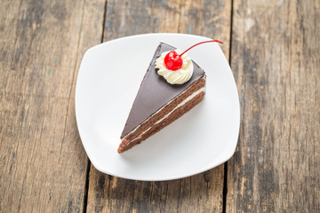 chocolate cake slice on plate on wooden table