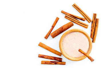 Cinnamon for cooking. Cinnamon sticks near bowl with sugar on white background top view copy space