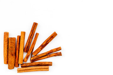 Cinnamon sticks on white background top view copy space. Condiment for mulled wine