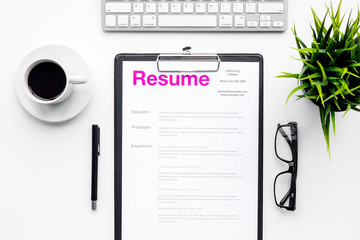 Create resume. Resume on white work desk with coffee, glasses, keyboard top view