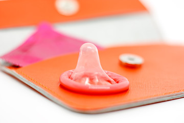 Male condom on orange bag